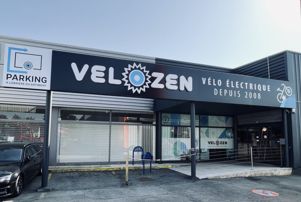 Façade du magasin Velozen avec enseigne indiquant « vélo électrique depuis 2008 »