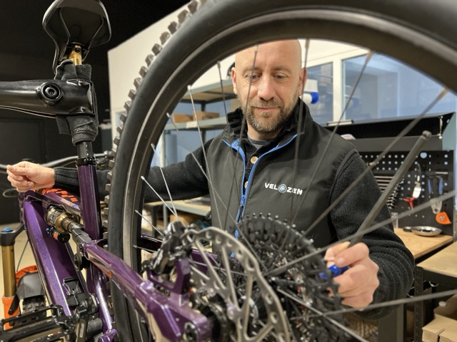 Technicien réparant un vélo électrique dans l'atelier Vélozen à Laval